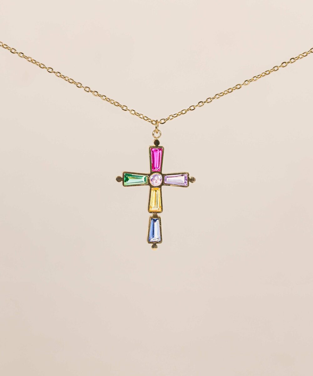 La cadena cruz cecilia es una cadena larga de 59 centímetros con un charm de cruz con circonitas de colores, una cadena llena de color y estilo.