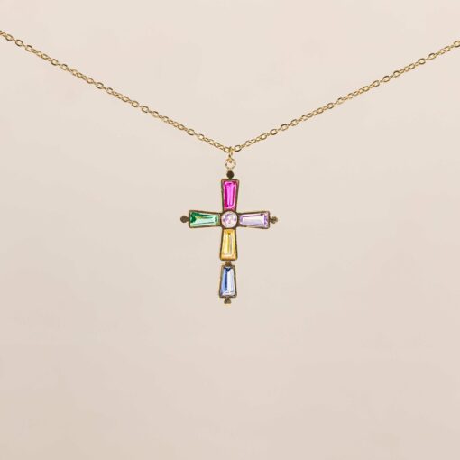 La cadena cruz cecilia es una cadena larga de 59 centímetros con un charm de cruz con circonitas de colores, una cadena llena de color y estilo.