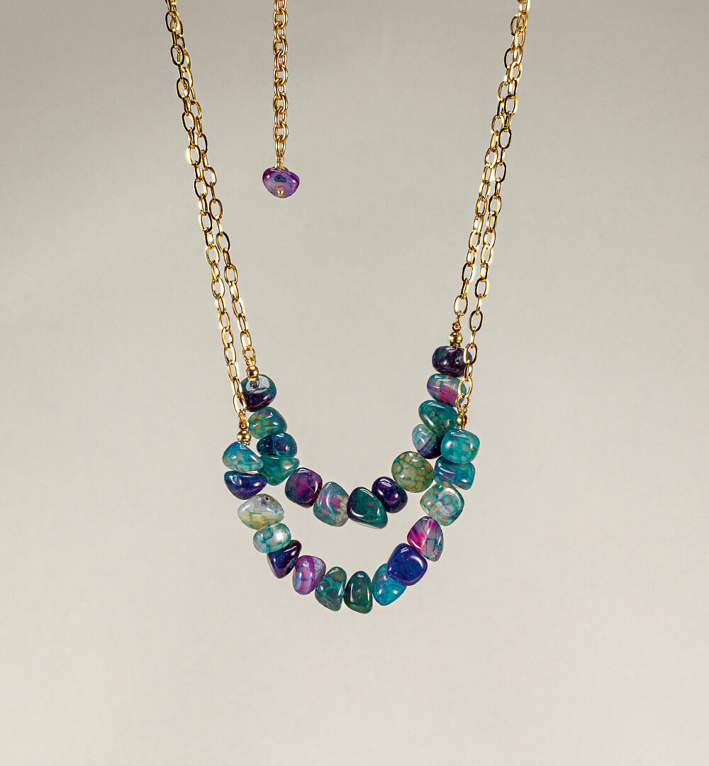 El Collar Mykonos es la joya perfecta para lucir esta temporada, tiene 2 vueltas de cadena de eslabones dorados y piedras en verde agua, violeta y azul.