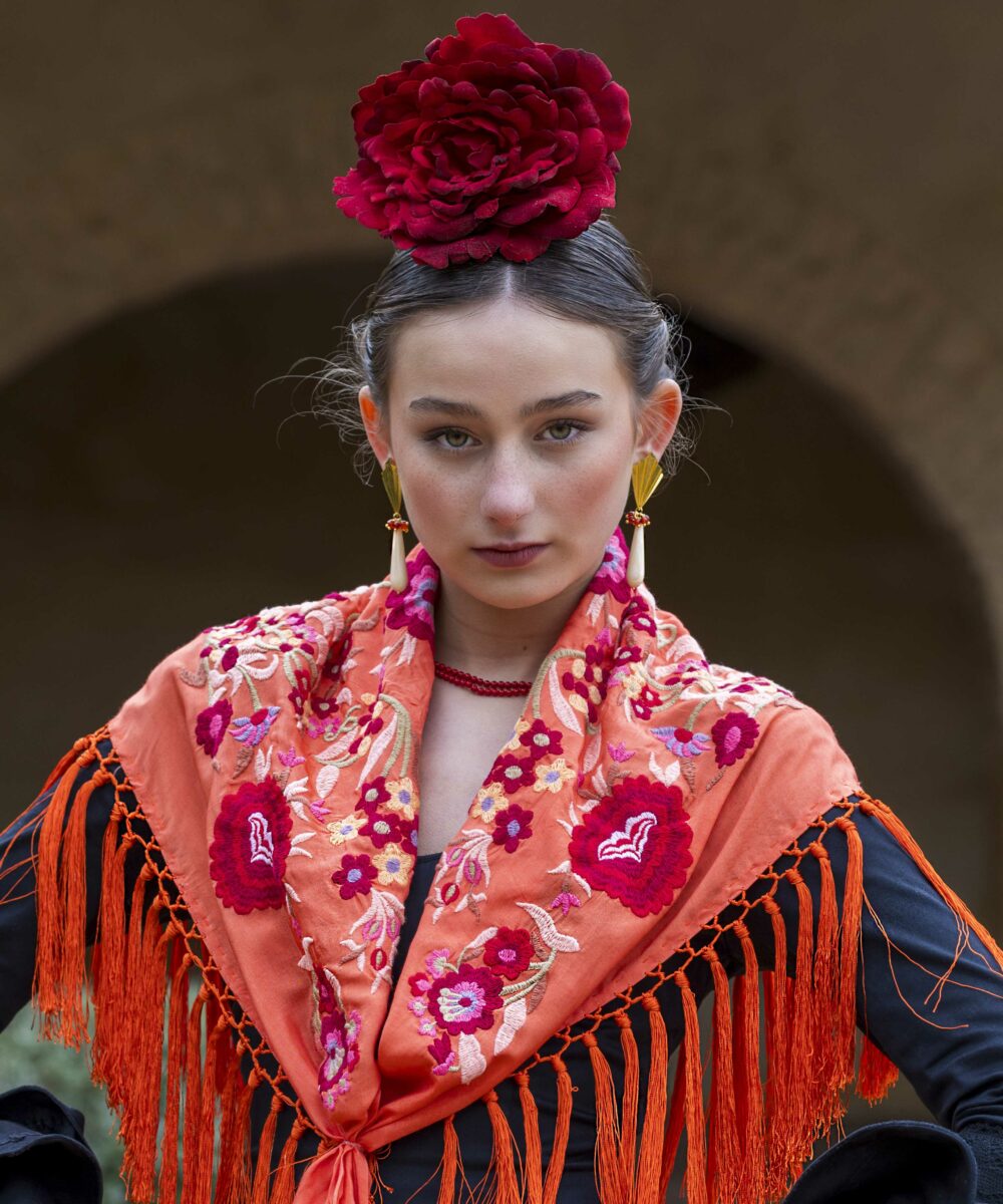 ¡Atrévete a lucir única y elegante en la próxima feria con el Mantoncillo Lola DW en naranja! Otro diseño propio de la colección flamenca 2025.