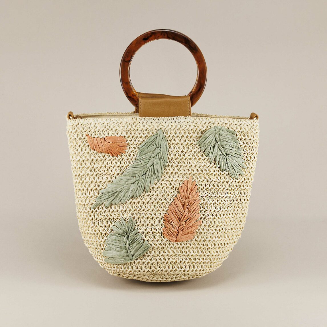 Bolso bucket de fibra natural Green con hojas bordadas en verde y terracota. Diseño artesanal con asas de carey y bandolera . Ideal para looks de verano.