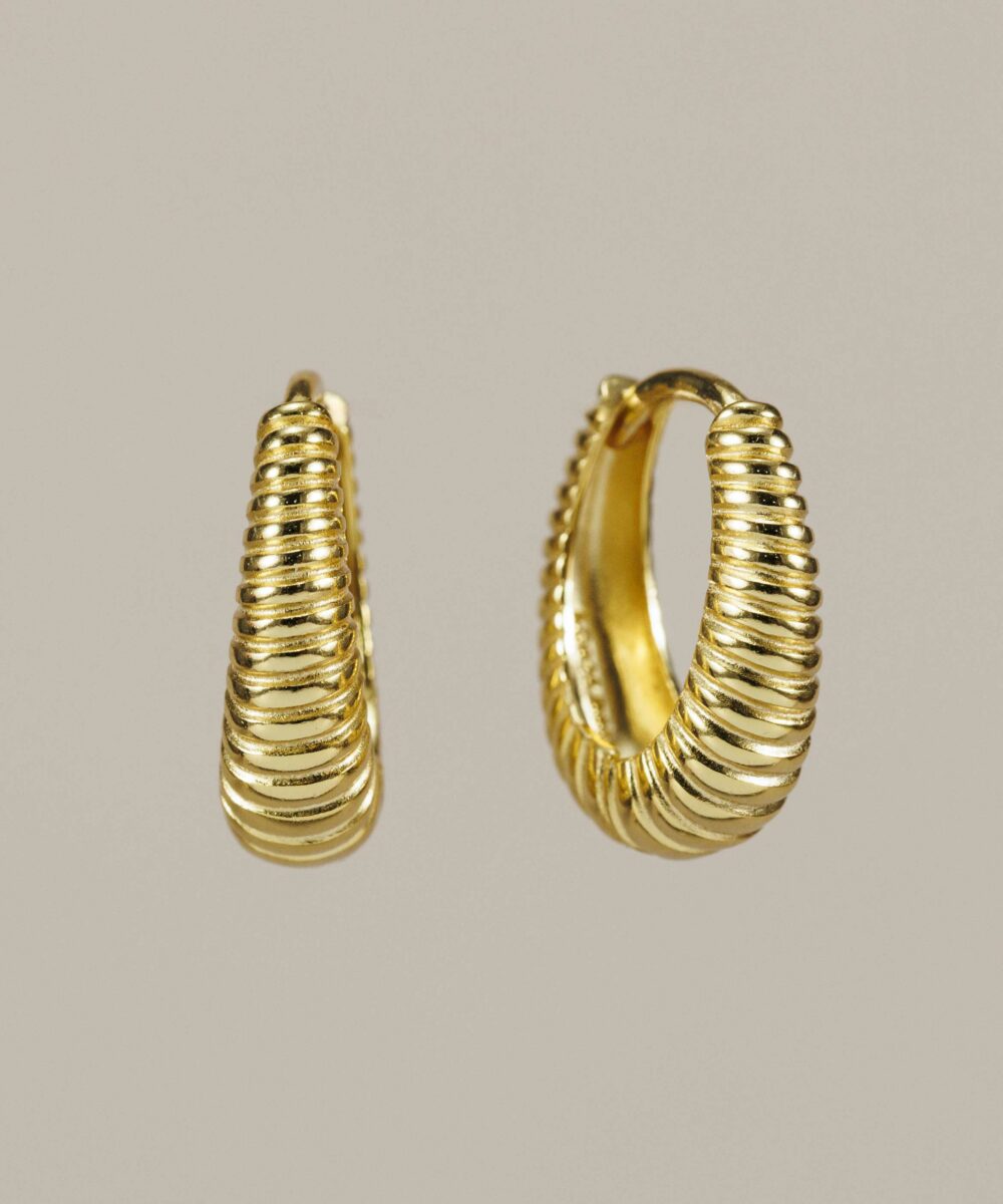 Pendientes de aro ovalado en plata 925 con baño de oro de 18k. Elegantes, cómodos y con relieve. El básico dorado que necesitas para tu joyero este verano.